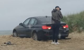 Мъж остана заключен извън колата си докато тя върти гуми в пясъка (ВИДЕО)