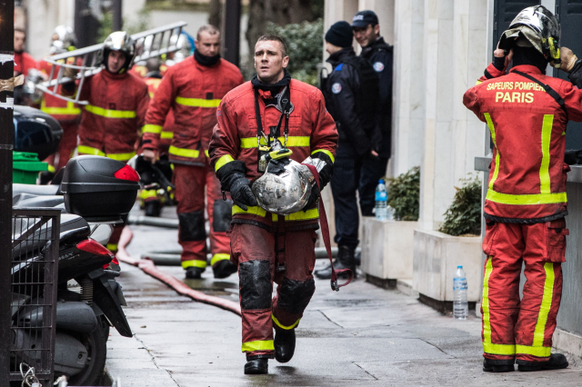 Жена стои зад огнения ад в Париж